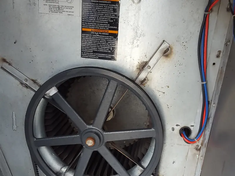 Interior de una unidad manejadora de aire: ventilador centrífugo, polea y correa de transmisión.